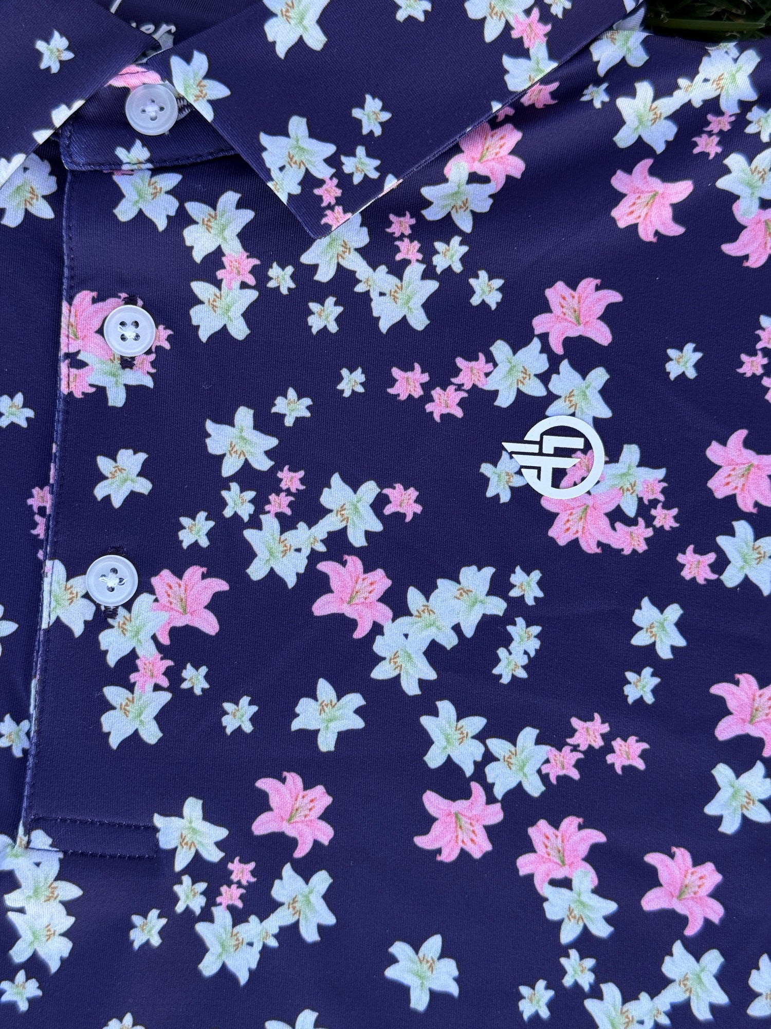 Navy blue fabric with pink and white floral pattern and logo in center