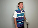 Man Wearing a polo with purple white teal and blue strips and a golf iron in his hand