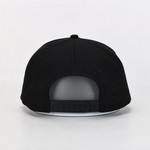 Black flat-brim cap shown from the back, featuring a perforated fabric crown and a black snapback closure on a white brim, photographed against a clean white background.