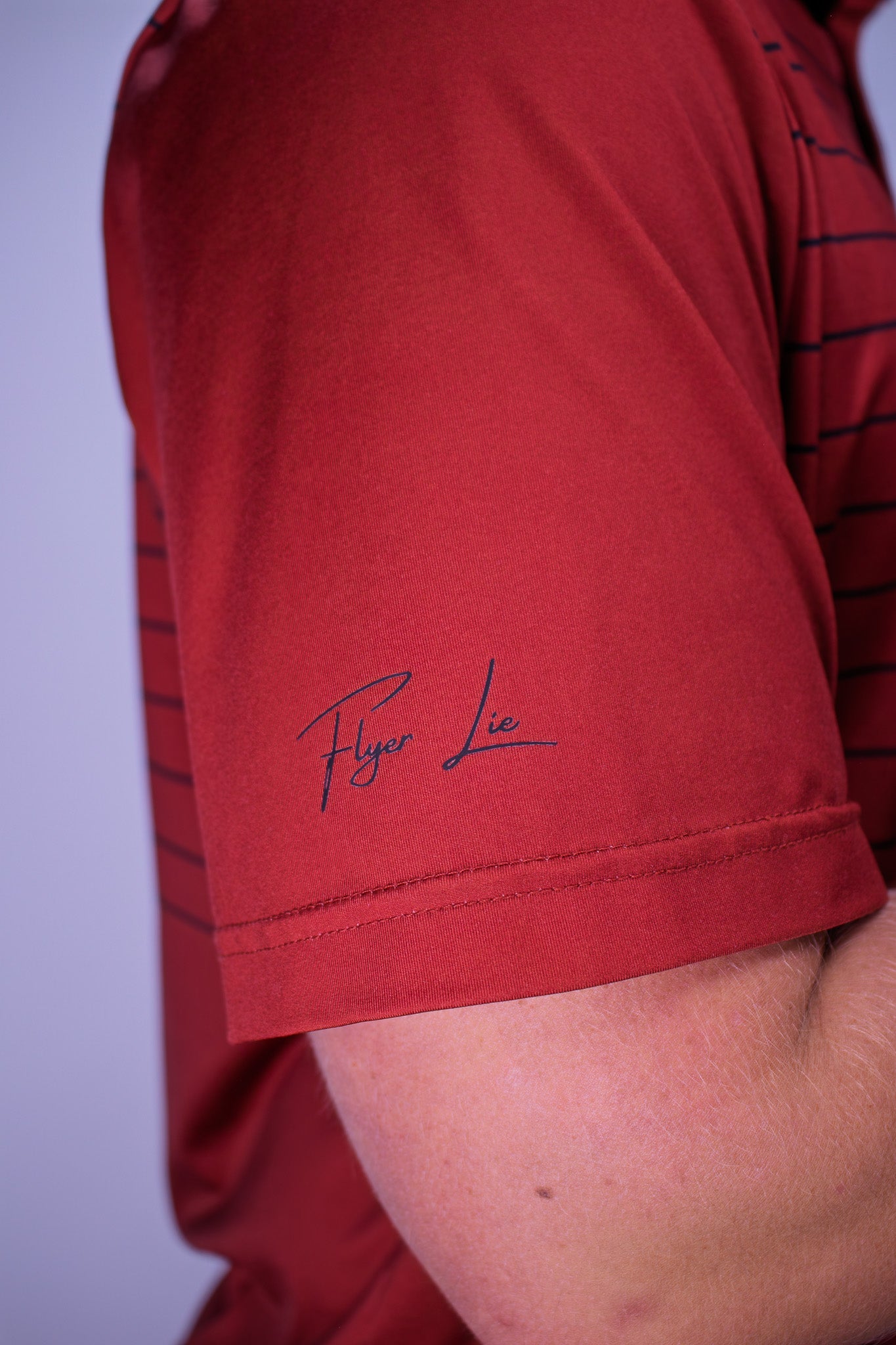 Red striped polo with cursive logo on sleeve