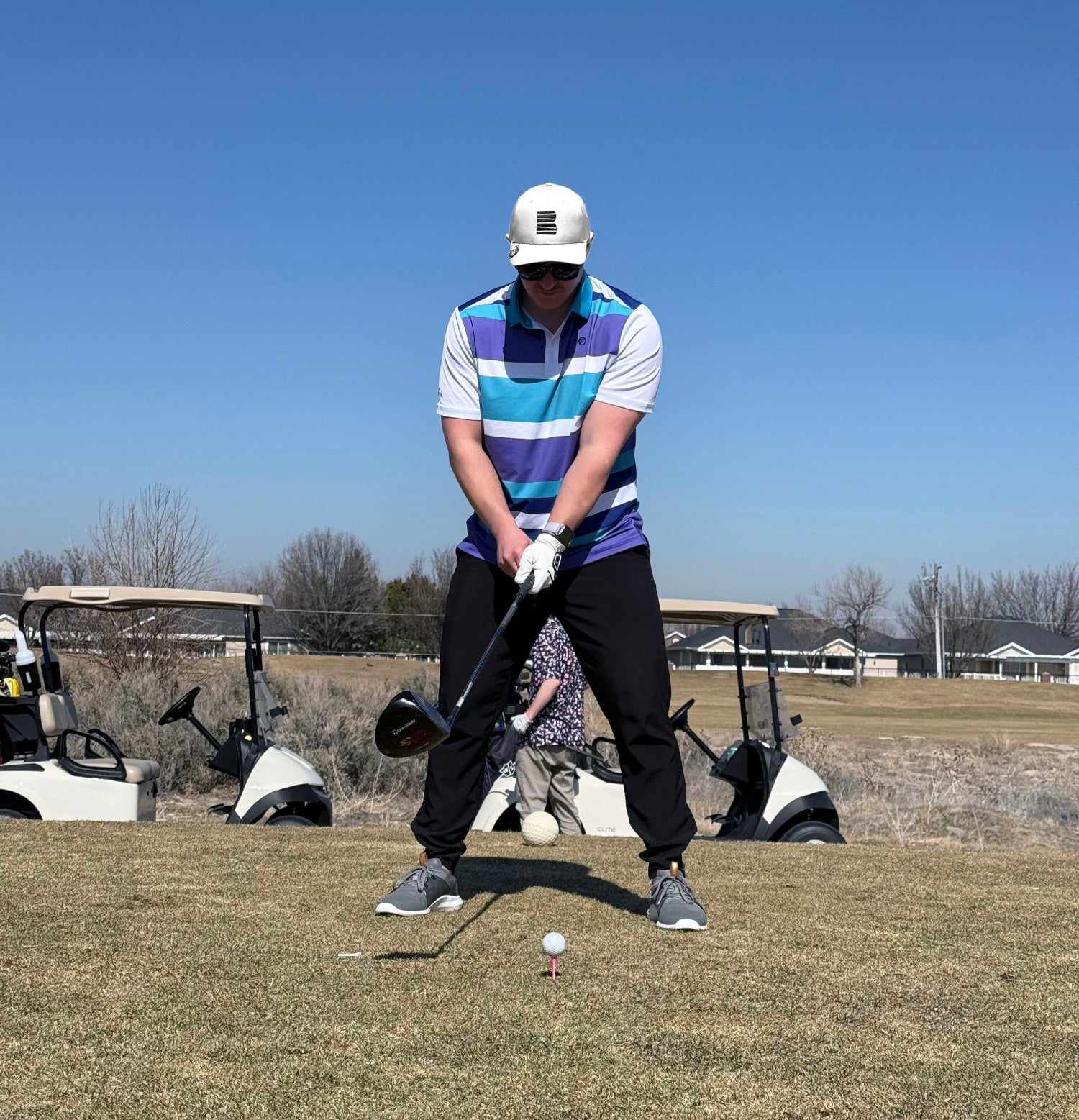 Man standing on tee box preparing to hit the golf ball 