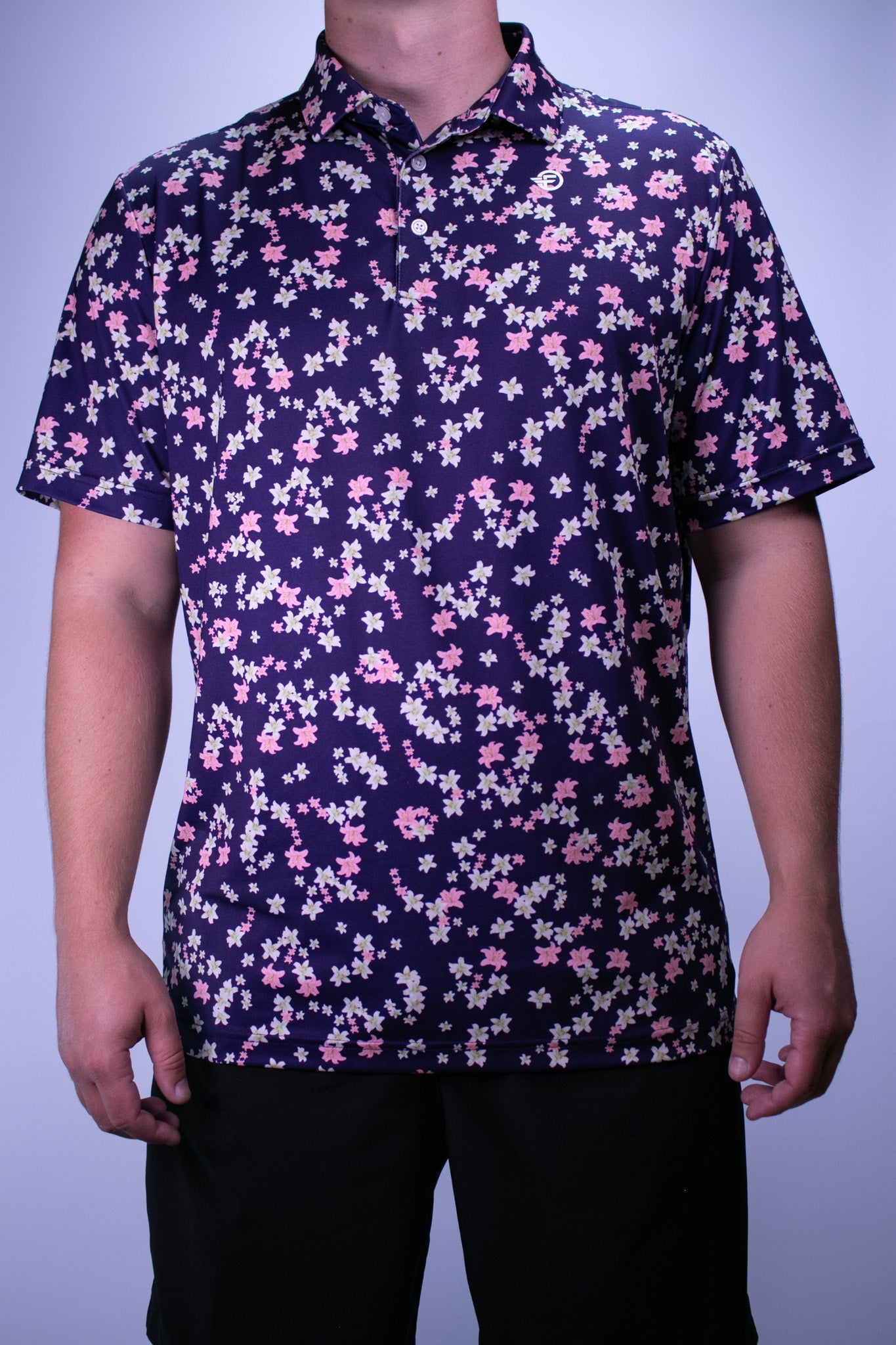 Person wearing a dark floral patterned shirt against a plain background