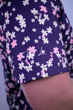 Navy shirt base with pink and white floral pattern and brand logo.